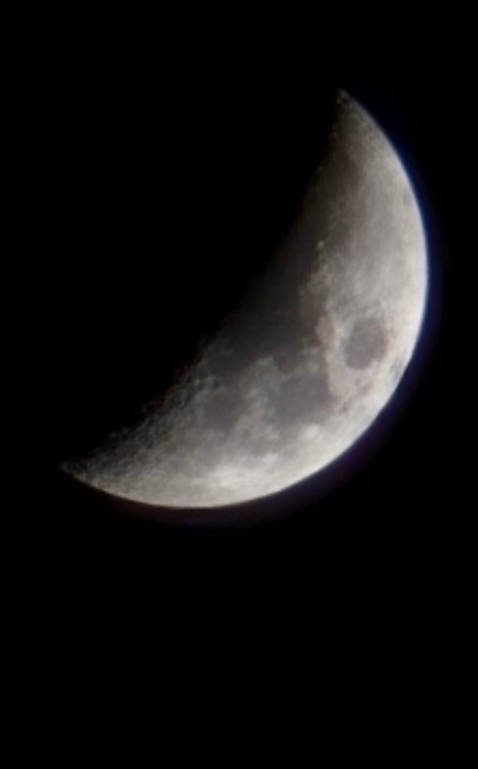 Waxing crescent moon in a night sky